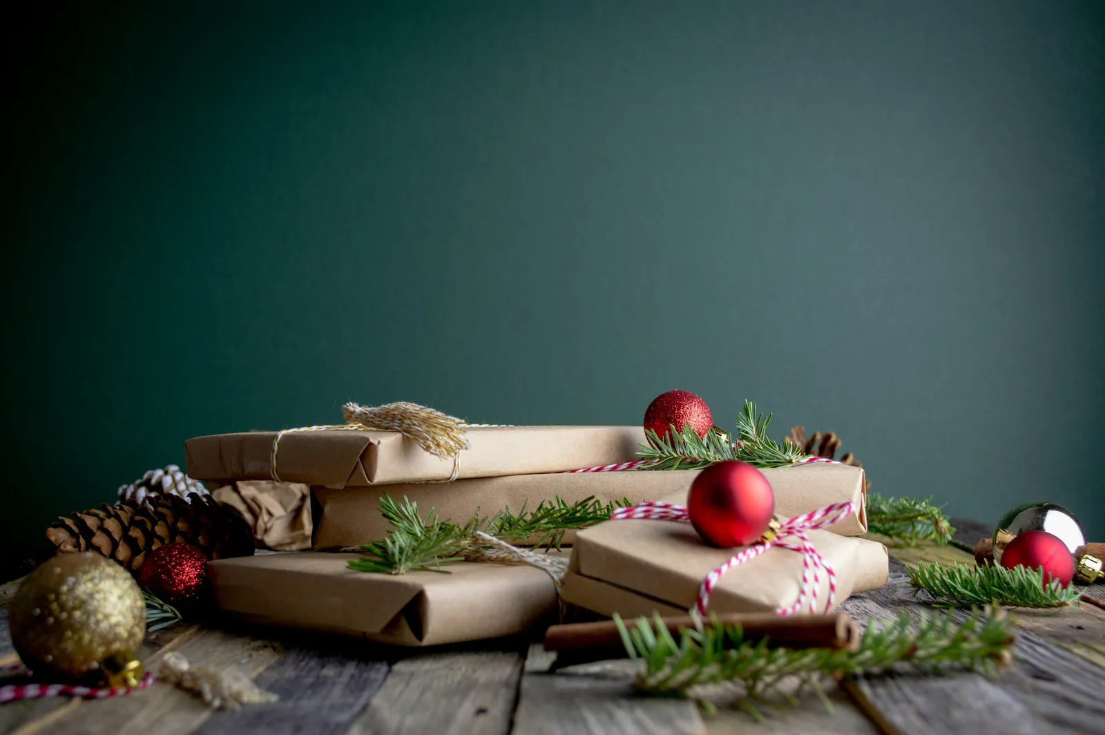 Paquets cadeaux en papier kraft décorés de boules de Noël rouges et de branches de sapin