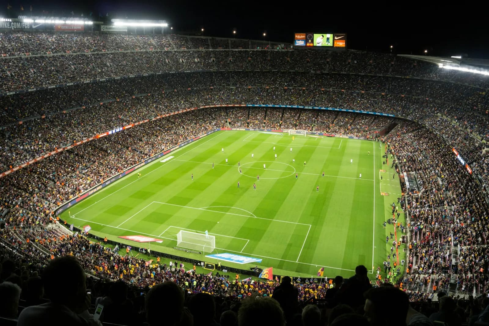 Stade de football plein de supporters pendant un match en soirée