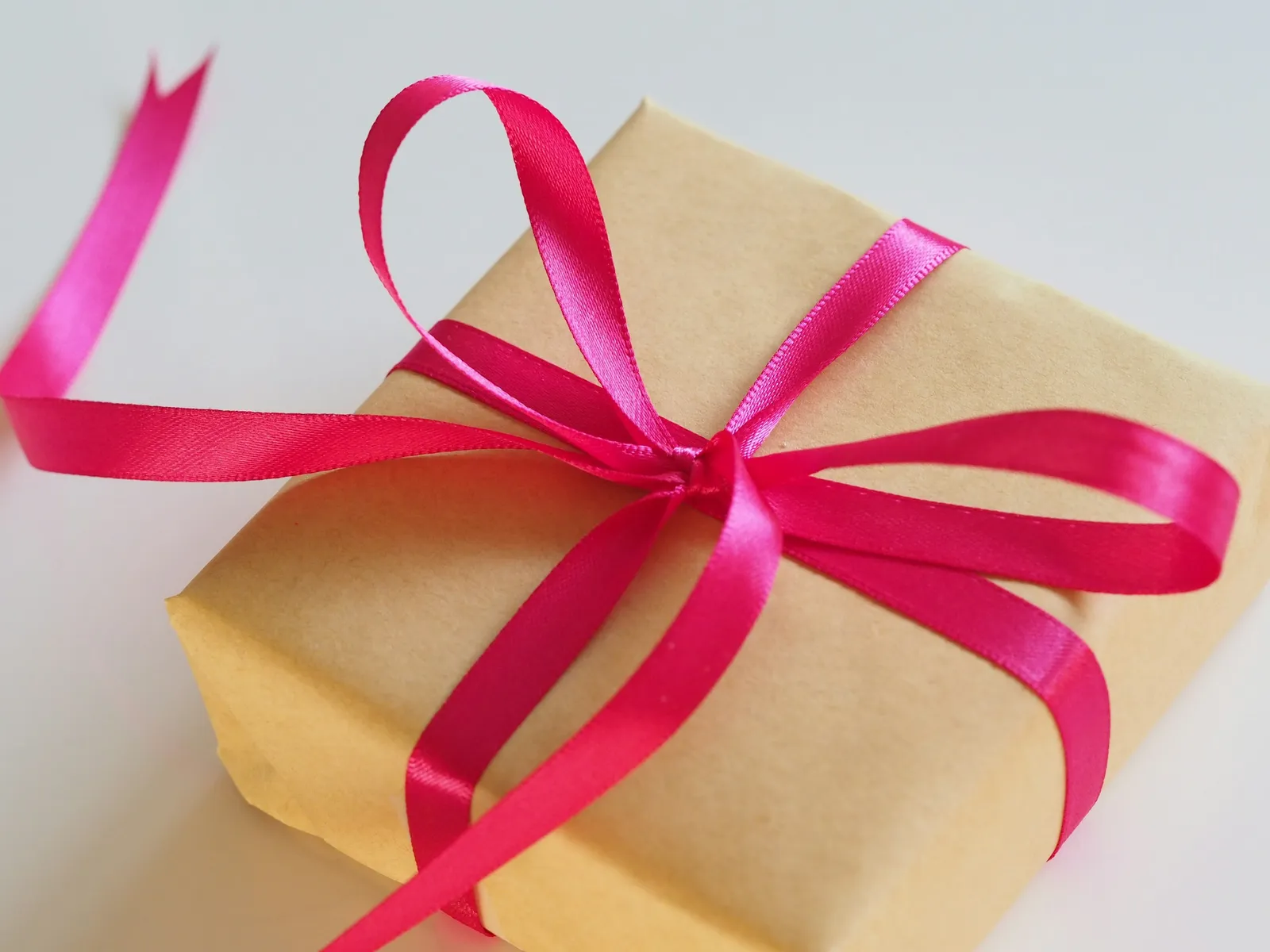 Boîte cadeau en papier kraft nouée d'un ruban rose