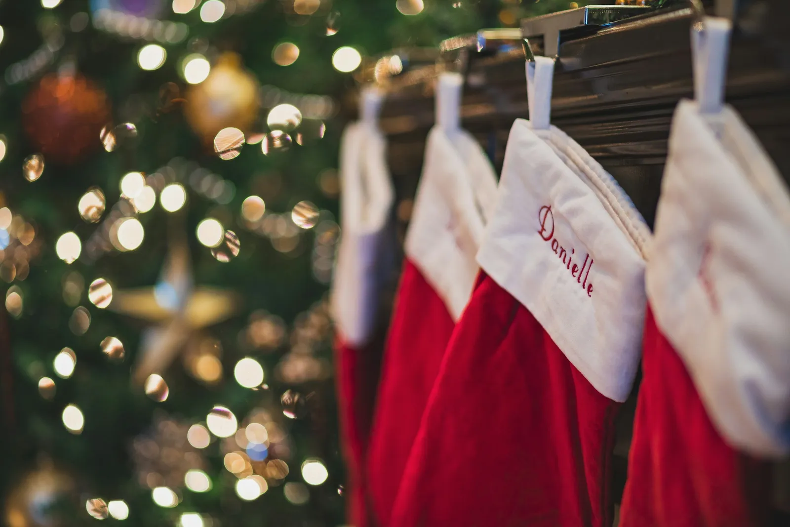 Chaussettes de Noël rouges et blanches suspendues devant des lumières de fête